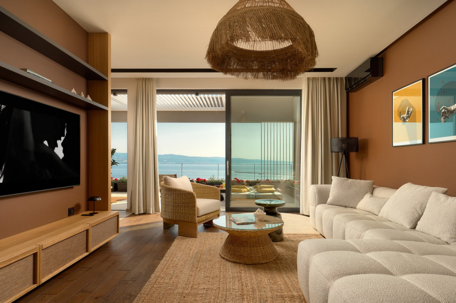 A connected dining area and a stylish and very nicely organized living room with a sofa and a TV