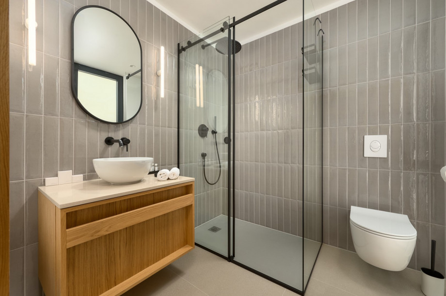 An en-suite bathroom with a shower, a sink, and a toilet
