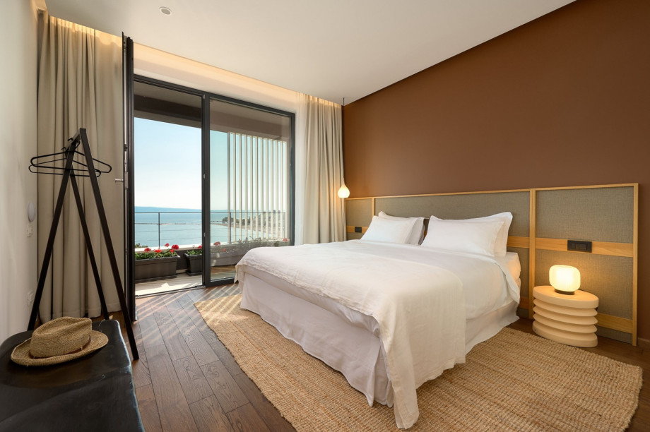 Schlafzimmer mit Ausgang auf eine 40 qm große Terrasse mit Lounge-Ecke und 2 Liegestühlen