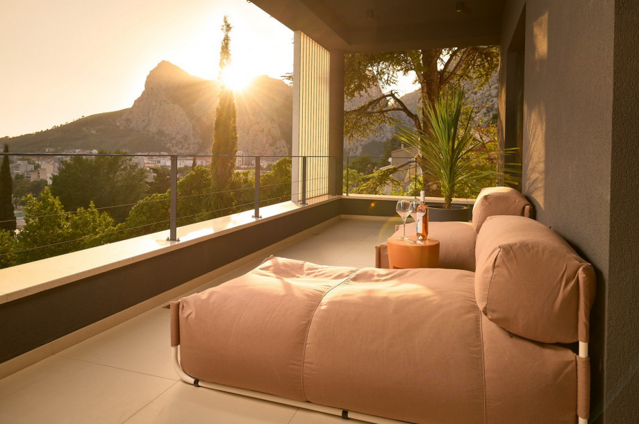 A covered balcony with comfortable and stylish furniture
