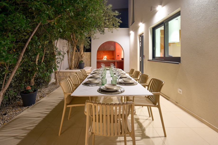 A spacious outdoor dining area with a barbecue (woods/charcoal)