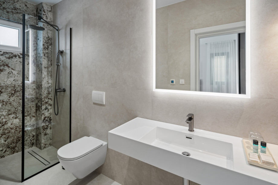 En-suite bathroom with shower, balcony, and sea views