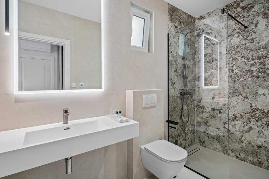 En-suite bathroom with shower, balcony, and sea views.