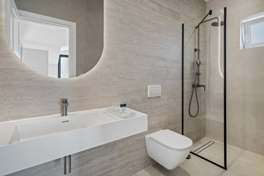 An en-suite bathroom with a shower, a sink, and a toilet