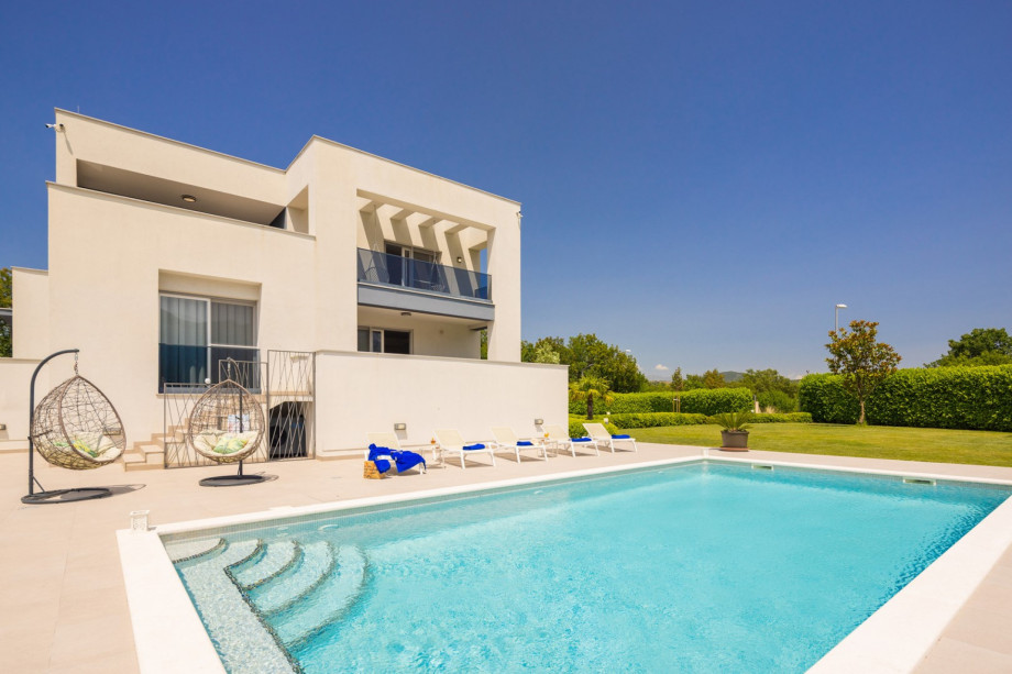 a private and heated, 5m x 10m swimming pool with a spacious sun deck area