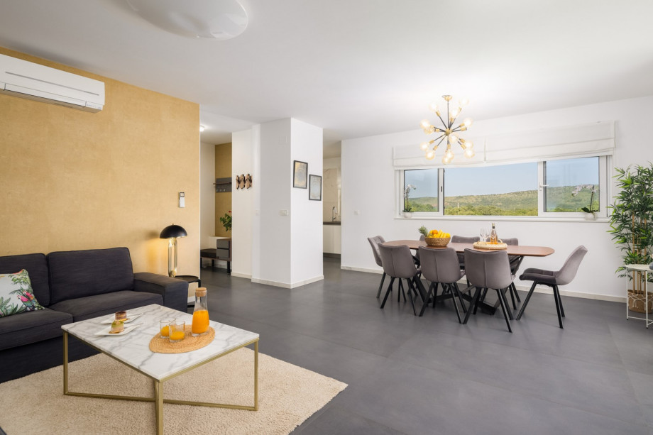 a fully equipped kitchen with a dining and living area with terrace and lounge furniture with a pool view