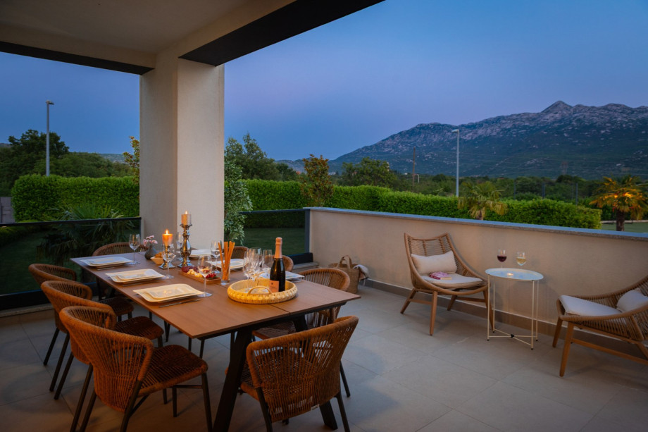 a covered outdoor dining area for 12 people with a barbecue (next to living and dining area at the ground floor level)