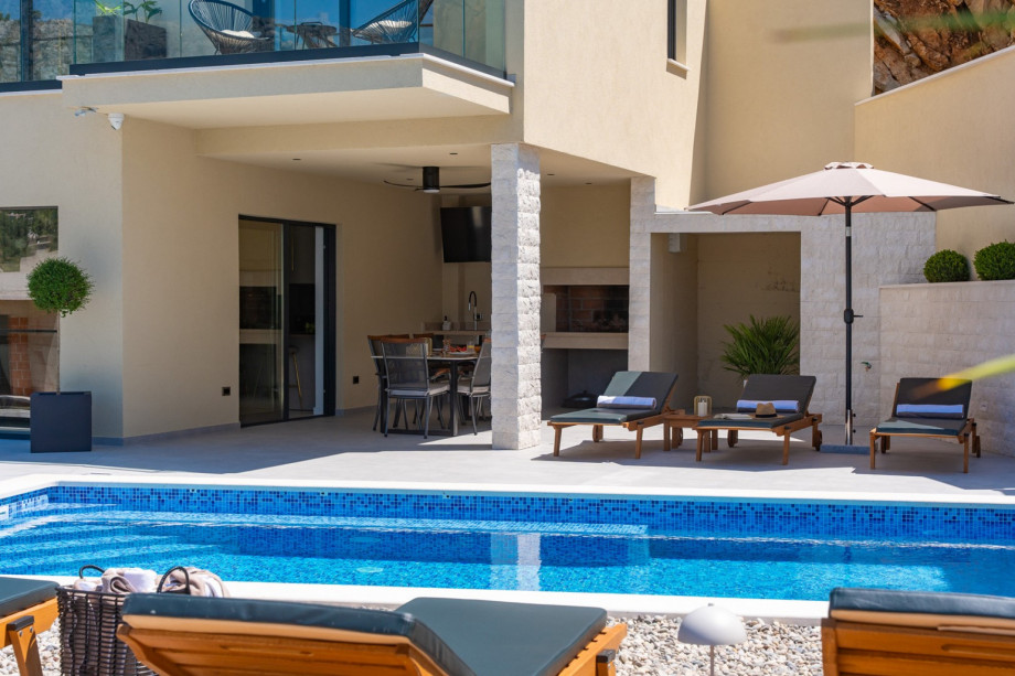 Sparkling swimming pool measuring 8,2 m by 4 m with large sunbathing area