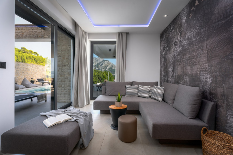 At the ground floor is a Media room with a flat-screen TV, PS5, Bose sound bar, air conditioner, a sofa (that can convert into a sofa bed)