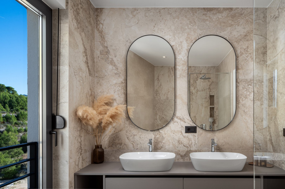 A family bathroom with a shower and two sinks, used by Bedrooms No2 and No3.