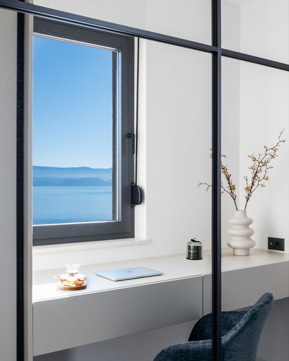A stylish office with an office table, a chair, and spectacular sea views