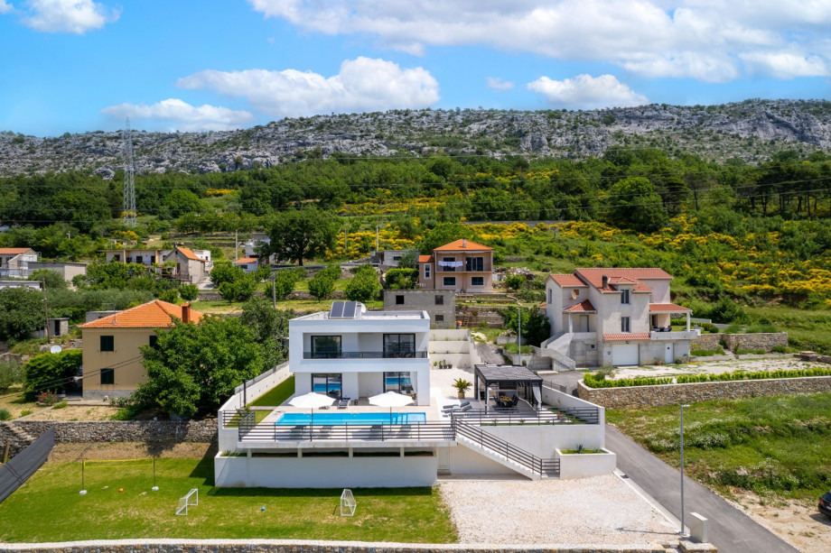 View toward Villa Mirage, with a children's playground, and a natural environment.