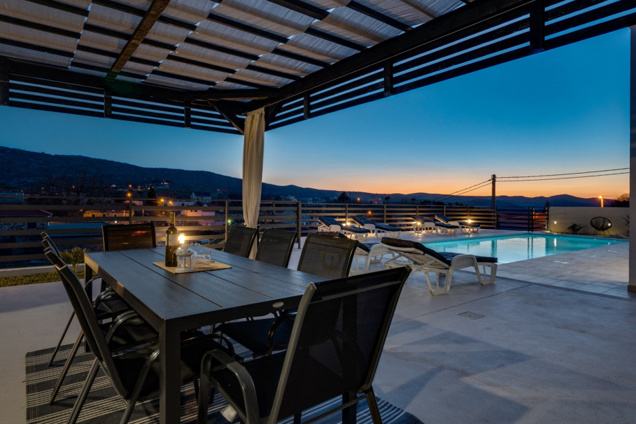 Covered outdoor dining area with a traditional barbecue for perfect evenings next to the pool.