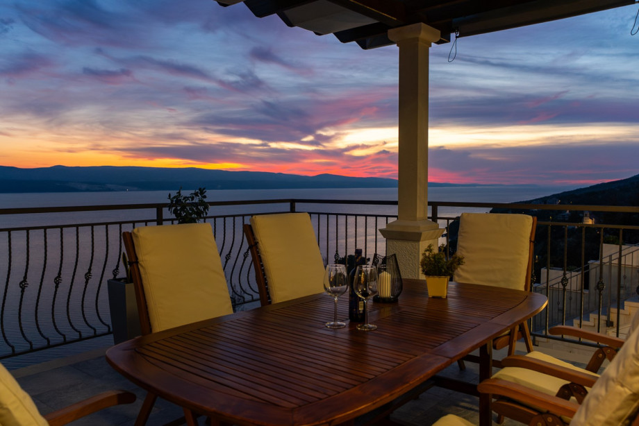 The upper dining balcony transforms into a magical space at sunset, perfect for enjoying dinner and wine while watching the sky change color over the sea