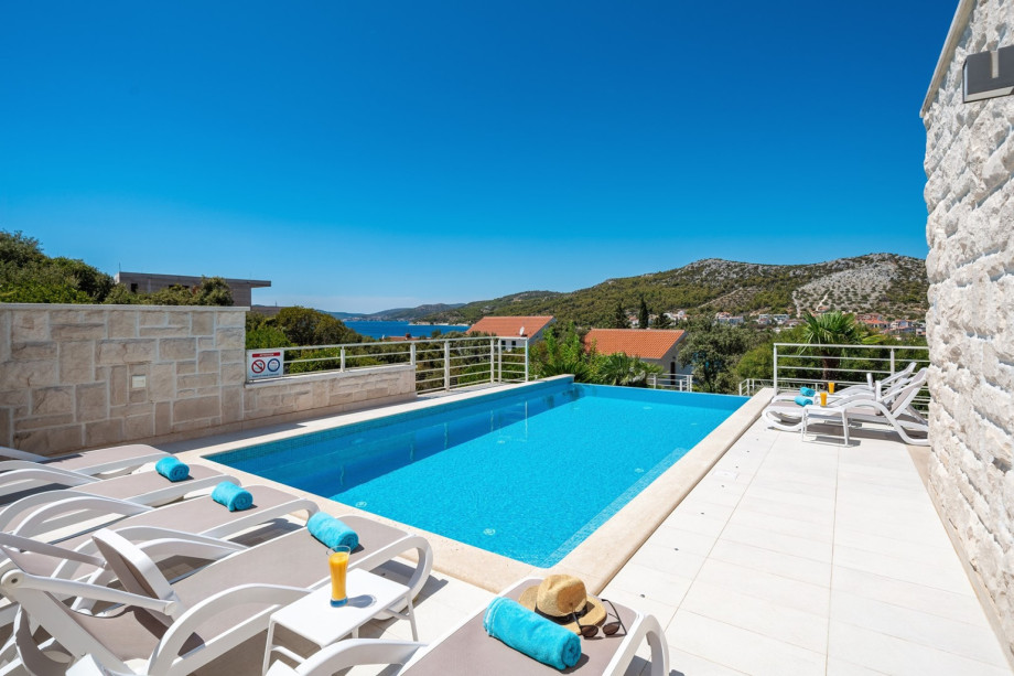 The outdoor area offers a sun deck with a sea view, a private and heated pool o with hydromassage, and a fully automated salt electrolysis system