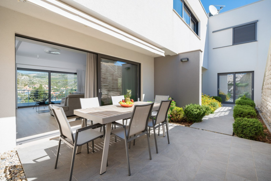 Dining area beckons guests to enjoy al fresco meals in style, complete with a summer kitchen
