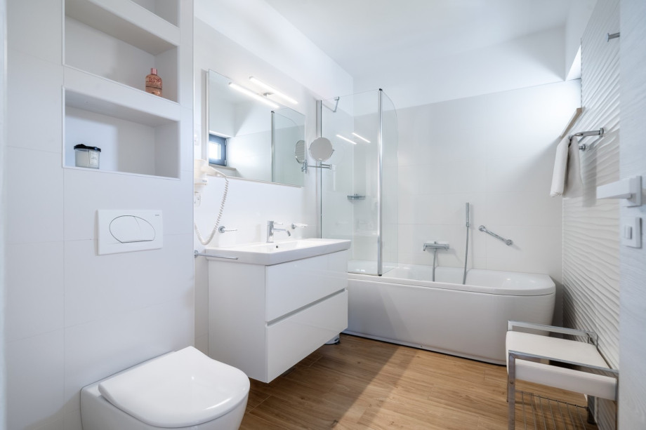 An en-suite bathroom with a bath tub, a sink, and a toilet