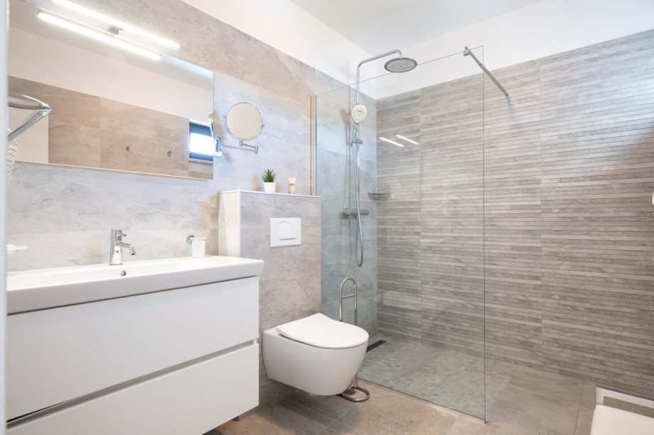 An en-suite bathroom with a shower, a sink, and a toilet