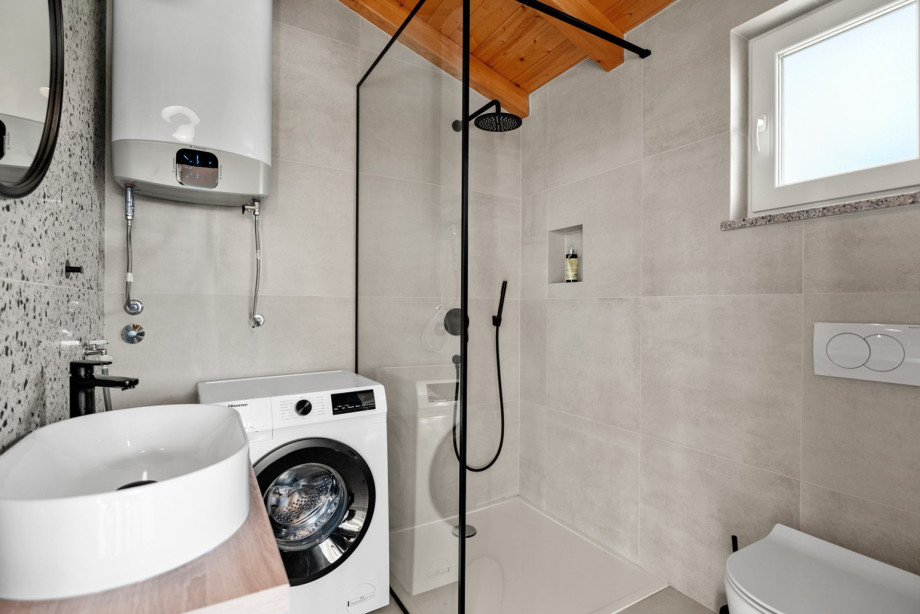 A family bathroom with a shower and washing machine