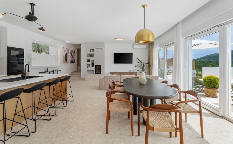 The sliding doors effortlessly connect the interior space to the inviting pool area, creating a fluid indoor-outdoor living experience