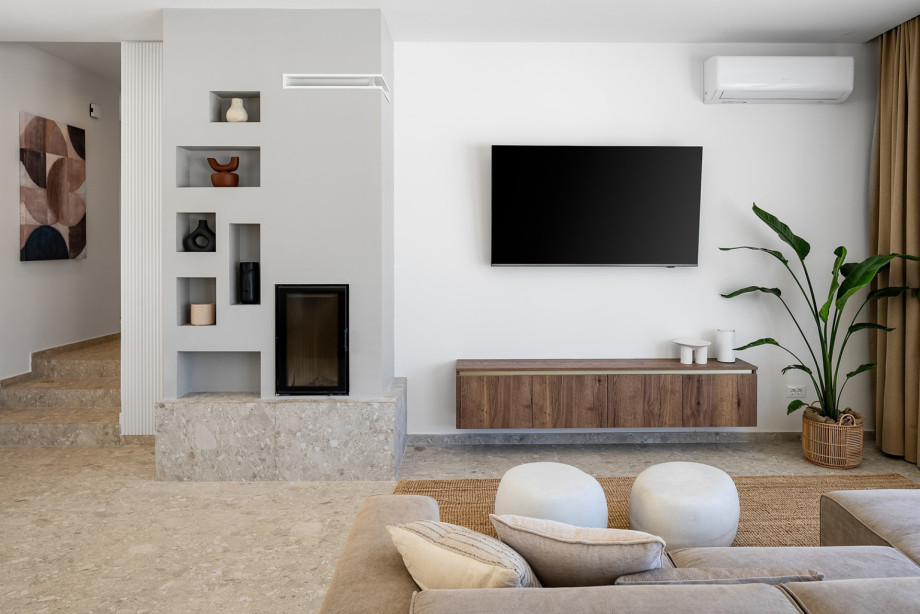 A living room featuring plush seating on a comfortable sofa, a large flat-screen TV, and a PlayStation 4 for added enjoyment