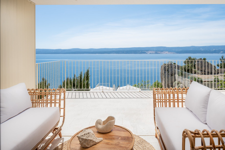 There is also a distinct laundry area equipped with a washing machine, dryer, ironing supplies, and a basin