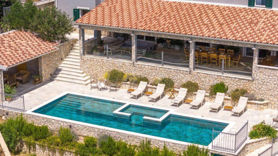 The pool is located on the lower position from the ground floor and the outdoor dining area.
