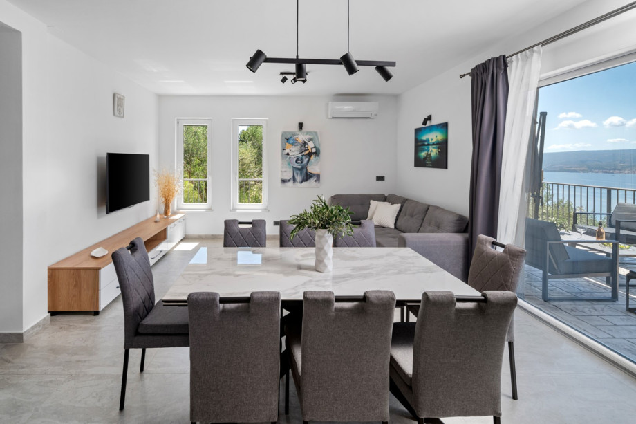 Dining table that opens directly to the pool and an outdoor lounging area, a living room with a comfy sofa that can be turned into a sofa bed measuring 120 cm by 190 cm