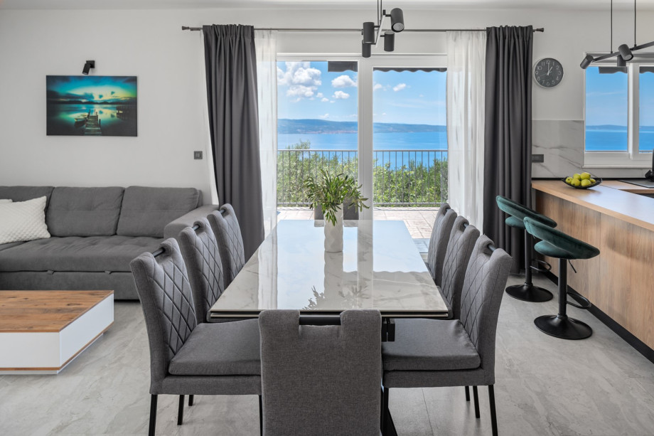 Dining table that opens directly to the pool and an outdoor lounging area, a living room with a comfy sofa that can be turned into a sofa bed measuring 120 cm by 190 cm