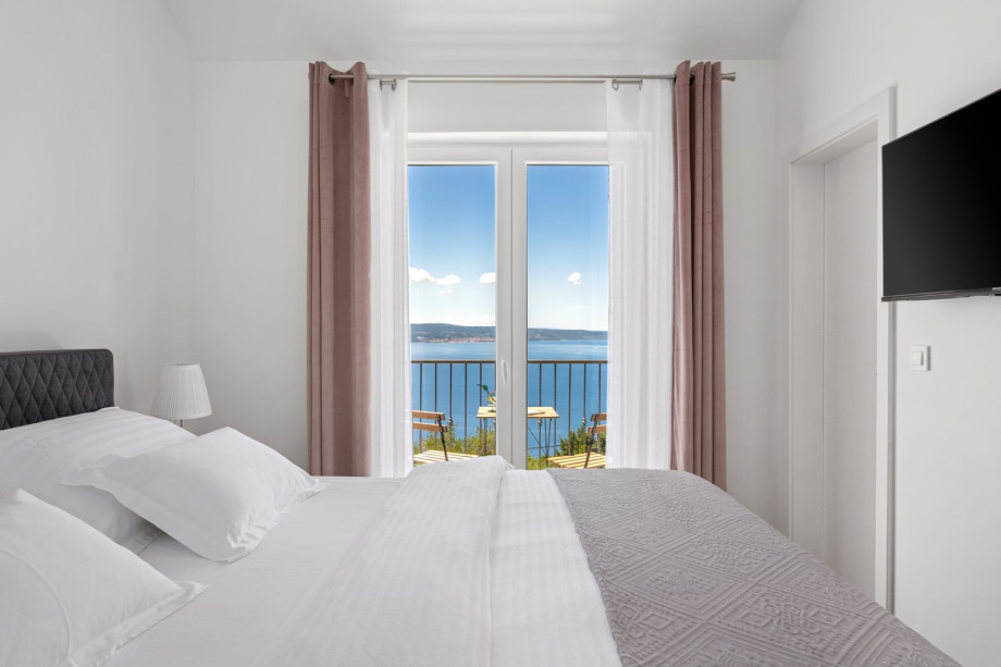 Bedroom No. 2 (10 sqm) has a queen-size bed measuring 160 cm by 200 cm, air conditioning, a TV, a shower, and a balcony with views of the sea