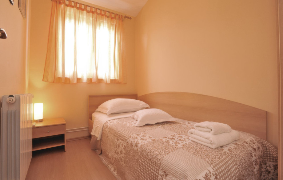 One of the cosy single bedrooms offers a comfortable bed and natural light, perfect for a peaceful rest.