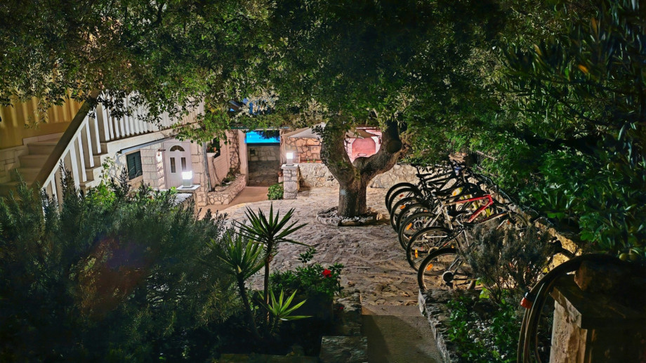 The entrance to Villa Ana is beautifully illuminated at night, highlighting the stone facade and lush, well-tended gardens.