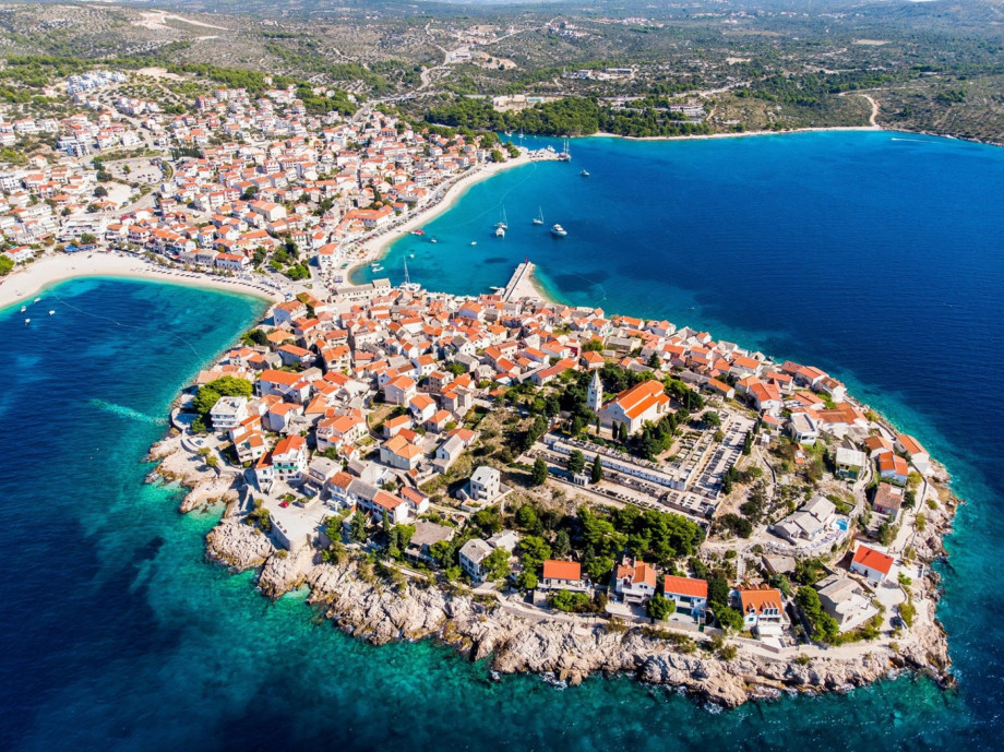 An aerial view highlights the stunning peninsula of Primošten (17 km), known for its beautiful beaches and historic terracotta roofs.