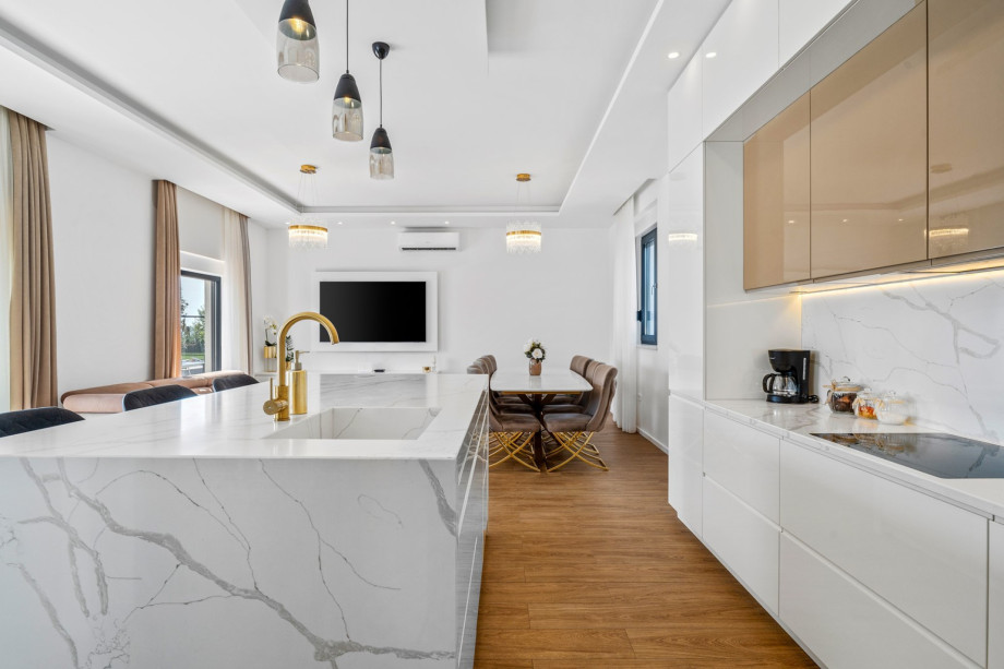 Fully equipped kitchen with dining and living room, and exit to pool area