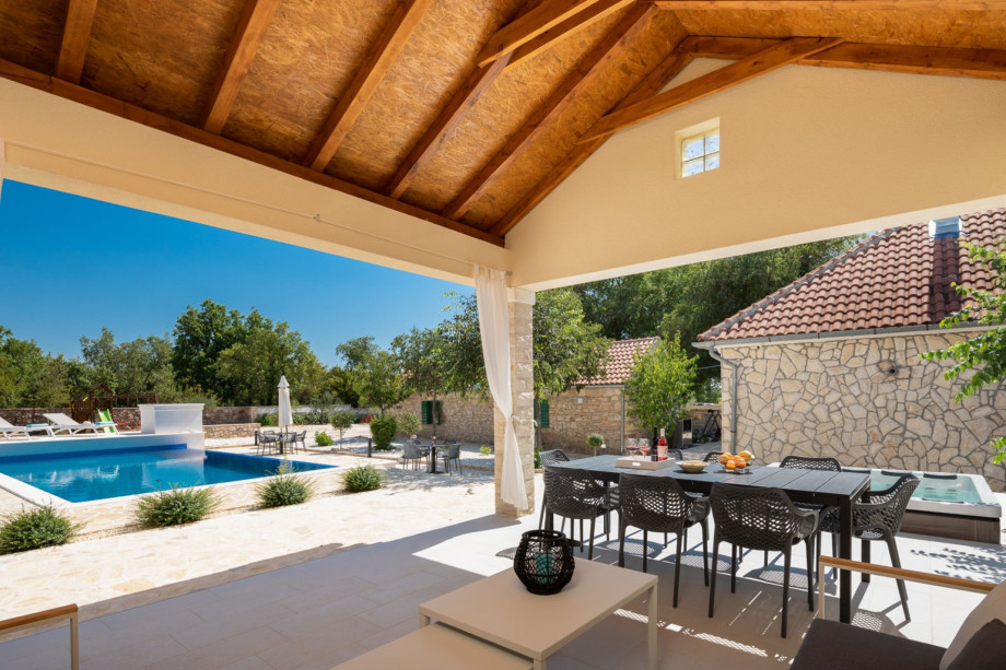 A covered terrace with a dining table