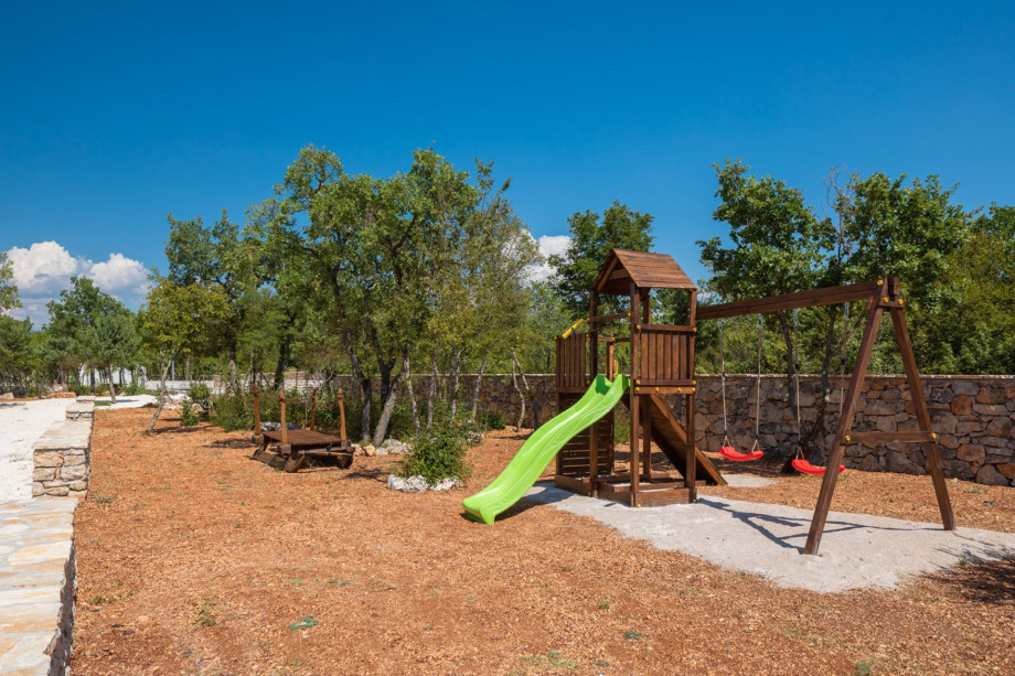 Children's playground with swings, a slide and small climbing frame
