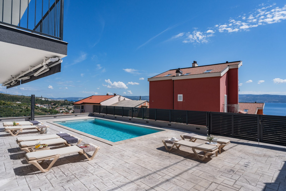 Large sun deck area with ten deck chairs, a lounge area, an outdoor shower