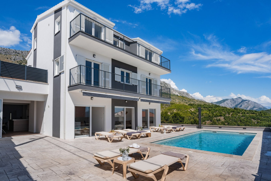 Large sun deck area with ten deck chairs, a lounge area, an outdoor shower