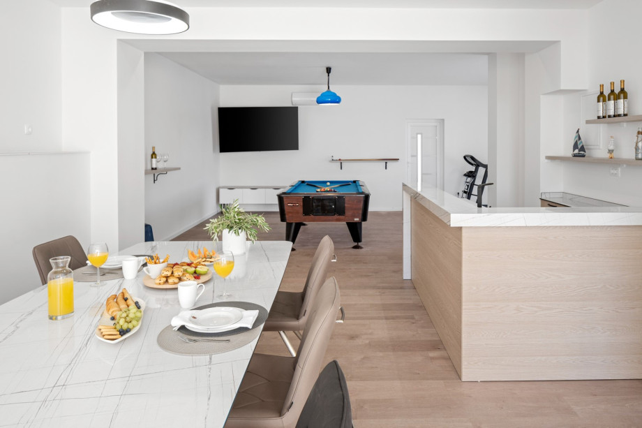 Fun zone with a dining table, a summer kitchen, a Pool table, a Treadmill and an Exercise bike