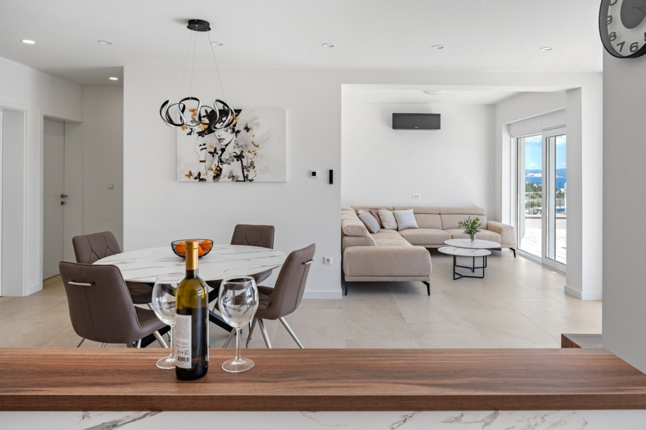 Ground foor with open concept living area and glass doors toward the pool