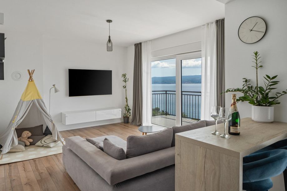 Open-plan living area that includes a fully equipped kitchen and a play area with a kid's tent