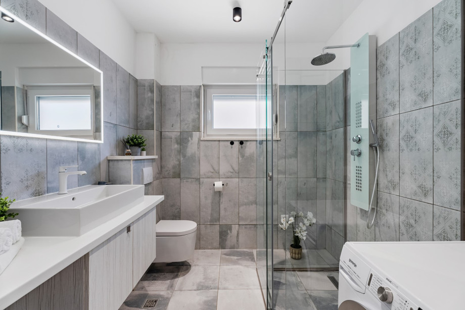 A family bathroom with a shower and a washing machine