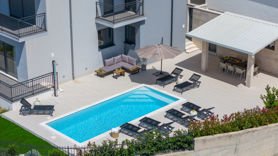 Private heated swimming pool, with sunbathing area