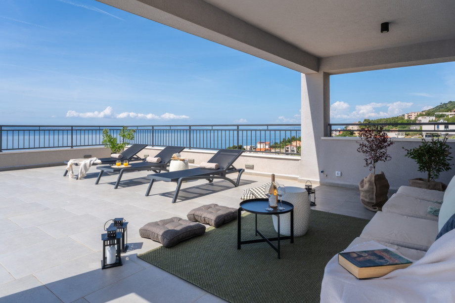 This residence boasts five spacious bedrooms, two fully equipped kitchens, and two inviting living rooms