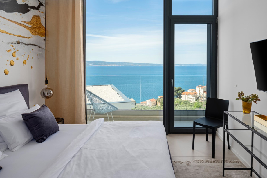 Bedroom NO2 with king-size bed and a balcony with views of the pool and sea