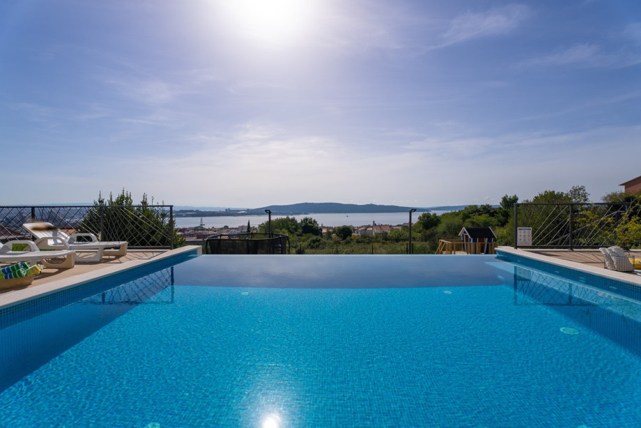 Sparkling swimming pool measuring 6 m by 6 m with a large sunbathing area