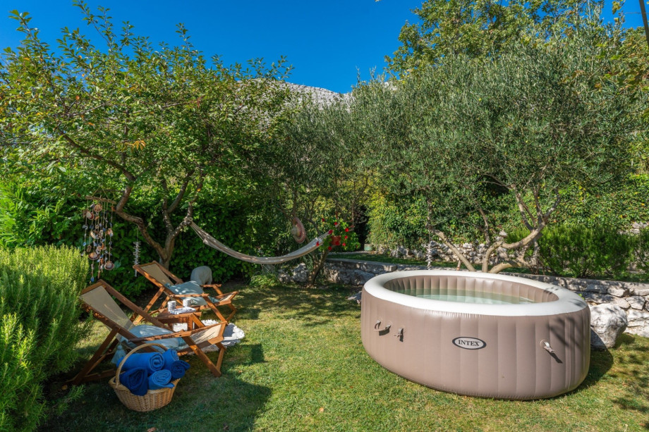 Grassplot with Softub Whirlpool, a lounge corner under the olive trees as a perfect spot to read and relax