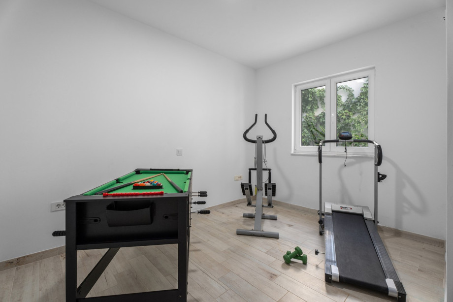 Exercise room with a Treadmill, Orbitrek, some weights, and multi combo game table