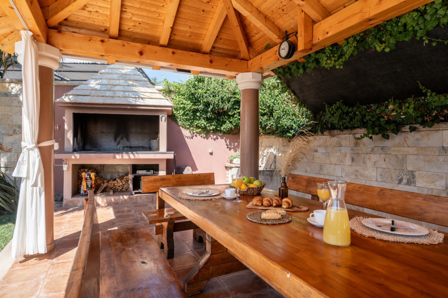covered outdoor dining area with barbecue