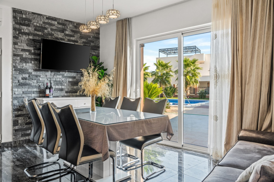 a living and dining area with fully equipped kitchen and exit toward pool area, A/C, TV